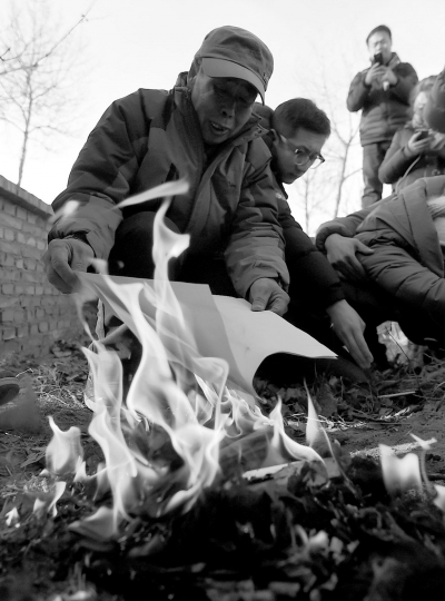 李三仁在兒子墳前焚燒再審無罪判決文書的復(fù)印件。新華社發(fā)