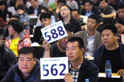 昨日，拍賣現(xiàn)場競拍者舉牌競拍。新京報記者