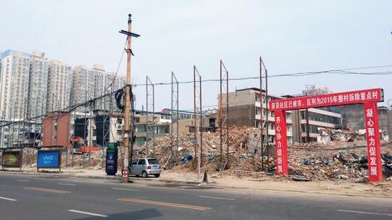 015年5月31日，在社區(qū)干部的帶頭拆遷下，親賢社區(qū)的“城中村改造”拉開帷幕。由于前期“清產(chǎn)核資”及補(bǔ)償標(biāo)準(zhǔn)等因素，拆遷改造工作推進(jìn)并不順利。圖為位于體育西路東側(cè)集體所有的商鋪率先被拆遷完畢，用于遮擋的圍擋正在施工中。（拍攝：2015年9月16日）