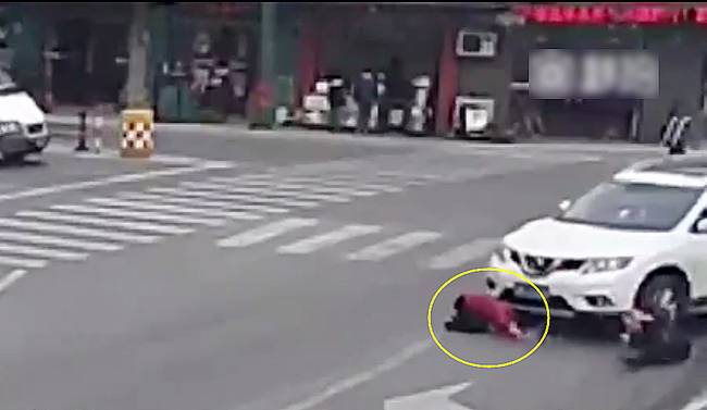 圖為小姑娘被卷進(jìn)車輪下瞬間。