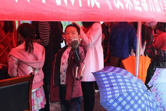 因為雨下的太大，小男孩玩起了接水游戲。