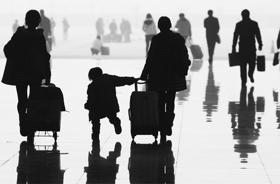 昨日，鄭州東站，一名孩子拉著媽媽和包裹快樂(lè)地奔走在春運(yùn)的途中