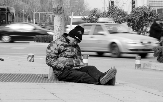 2月2日，鄭州市中州大道農(nóng)業(yè)路立交橋下，50歲的王文德打算在臨近春節(jié)前再接些零活兒，由于疲憊，他睡著