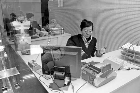 2月16日，鄭州市自來(lái)水總公司鄭東新區(qū)一營(yíng)業(yè)廳，柜臺(tái)內(nèi)工作人員正在為市民辦理業(yè)務(wù)