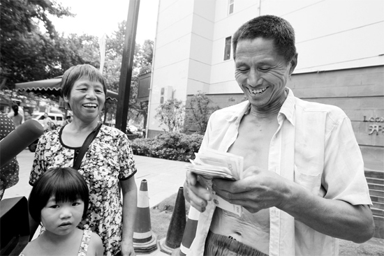 昨日，鄭州市明達(dá)路與豐慶路交叉口西300米路南，來自中牟的瓜農(nóng)拿到西瓜款，笑開顏東方今報記者袁曉強