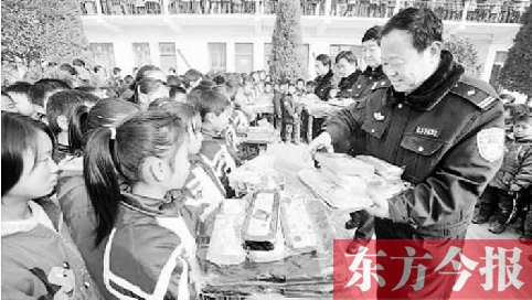 潘永朝（右一）生前在給孩子們發(fā)放捐贈(zèng)的書(shū)籍 資料圖片