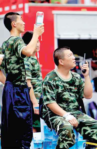 火場外，被消防戰(zhàn)士稱為“李大隊(duì)”的救援人員掛著吊瓶現(xiàn)場指揮