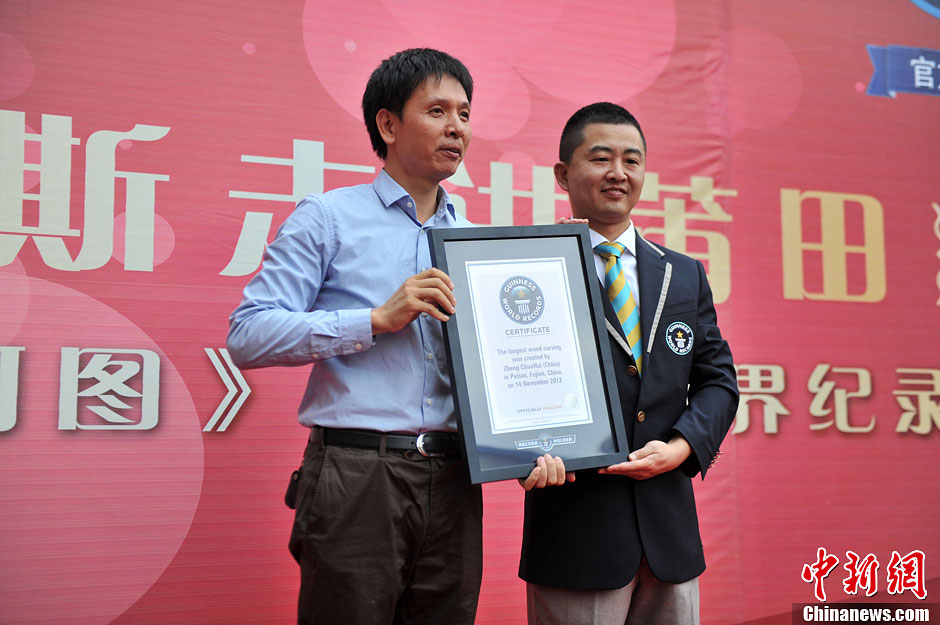 圖為世界吉尼斯認(rèn)證官為鄭春輝（左）頒發(fā)證書(shū)。呂明 攝