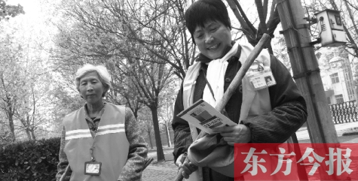 　徐大媽（右）拿著自制的英語卡片認真學(xué)習(xí)