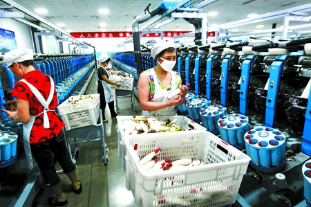 6月6日，舞鋼市鑫海紡織有限公司員工正在新建成的紡紗車間生產(chǎn)。