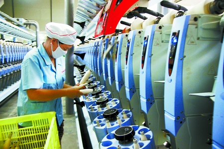 7月3日，在鄧州市永泰棉紡有限公司電腦控制全自動(dòng)紡紗車間，紡織工人正在生產(chǎn)棉紗。