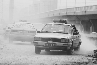 施工的道路上，車輛通過(guò)塵土飛揚(yáng)。