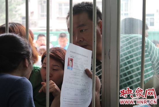 不少家長(zhǎng)擠在報(bào)名窗口前咨詢(xún)報(bào)名事宜。