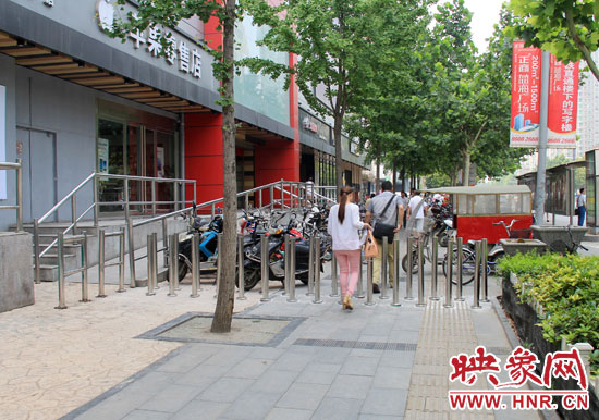 圖中道路左側(cè)的無(wú)障礙通道被鋼管隔離,右側(cè)的盲道也被侵占。