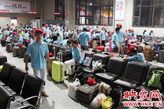 大學生志愿者在火車站候車室內(nèi)整裝待發(fā)。