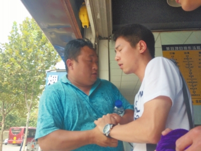 記者正查看照片，突遭藍(lán)衣男強(qiáng)搶手機(jī)。