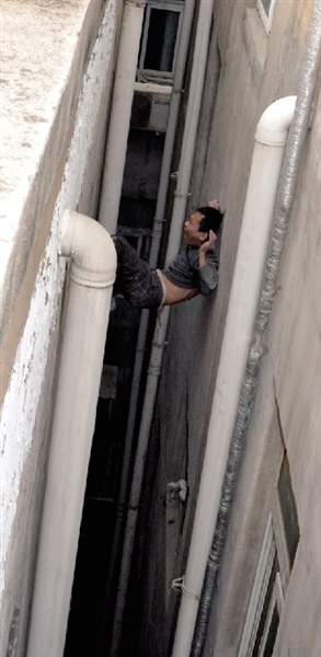 就在民警緊急施救時(shí)，他從兩樓之間摔下。