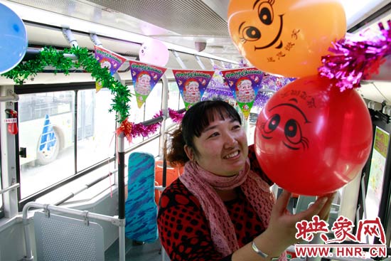 鄭州快速公交B3區(qū)間線車長李鵬云在車廂里懸掛氣球，布置圣誕車廂，營造歡樂圣誕氛圍