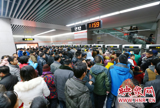 地鐵開通首日，上午十一點五十九分，紫荊山地鐵站售票機(jī)前擠滿了買票的市民。