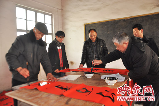 鞏義市魯莊鎮(zhèn)農(nóng)民書法愛好者正在寫春聯(lián)。