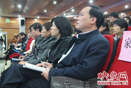 認(rèn)真聽取招生政策的學(xué)生家長。