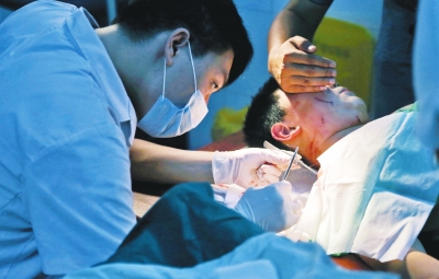 孩子身上有7道傷痕，其中兩道需要縫合，其他的均為擦傷，醫(yī)生正對(duì)他施治。