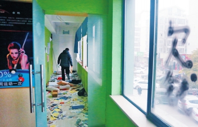 　健身會所地上一片狼藉，玻璃上噴著黑色“欠錢”二字。