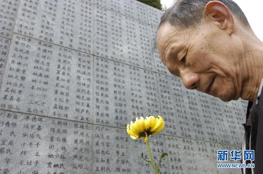 2006年4月5日，74歲的南京大屠殺幸存者佘子清手捧鮮花，祭奠被日軍殺害的母親。