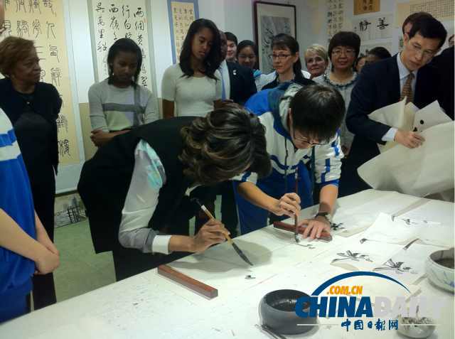 　北京時間3月21日，美國第一夫人米歇爾參觀北師大二附中時，與學(xué)生一起練習(xí)書法。