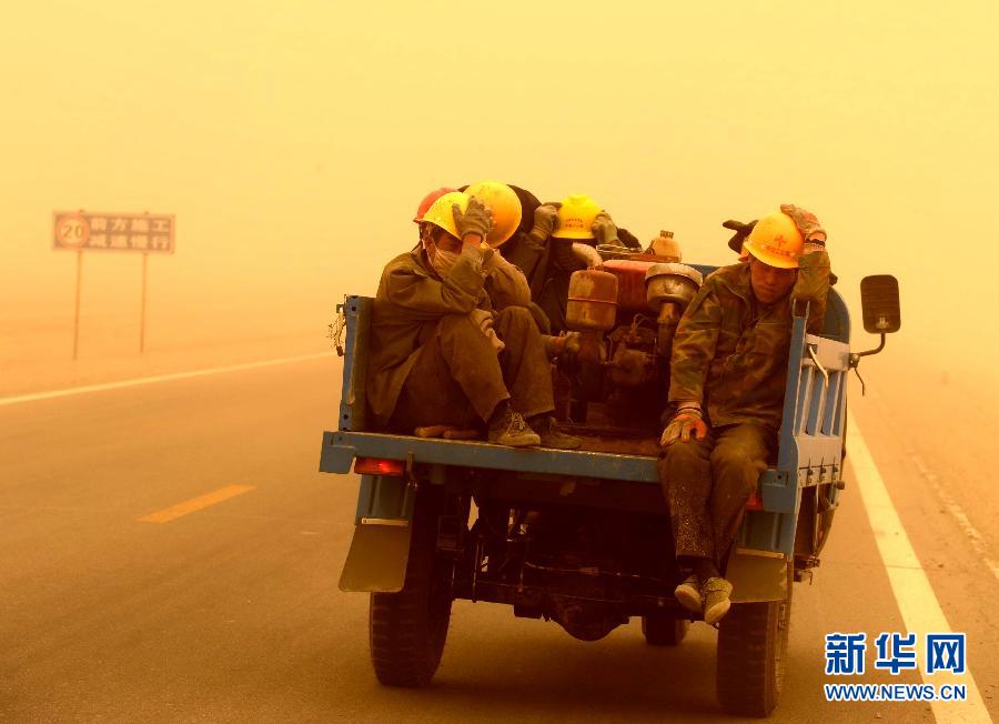 4月23日，一輛拉載公路施工人員的三輪車在沙塵暴中行駛在酒泉市瓜州縣城郊的公路上。