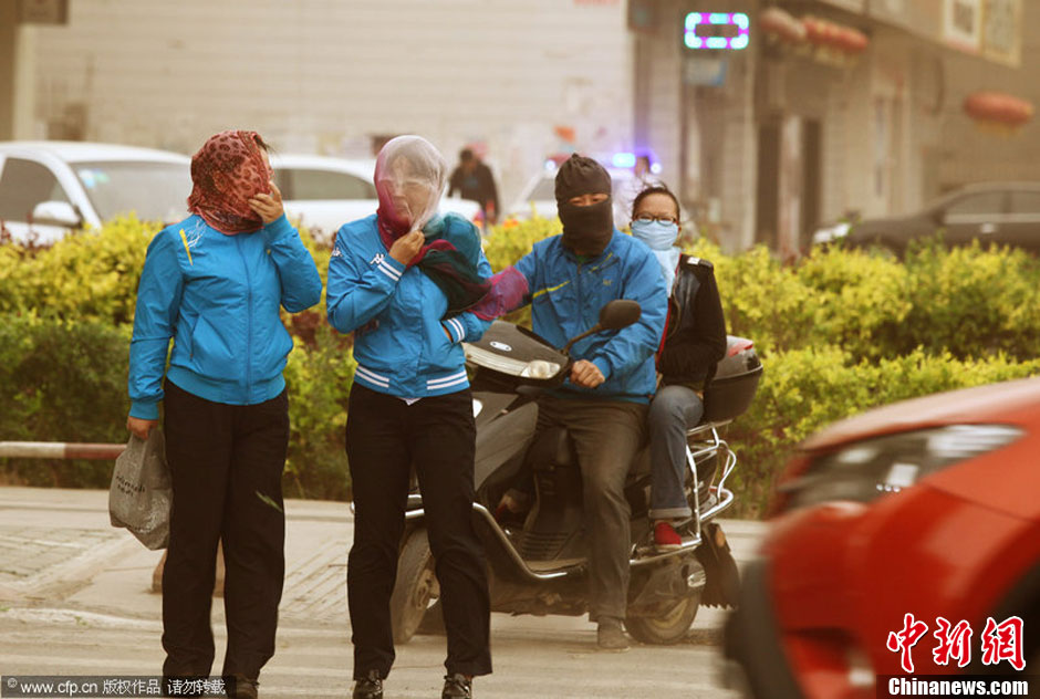 2014年04月23日，新疆維吾爾自治區(qū)吐魯番地區(qū)，市民戴著口罩行走在大風(fēng)沙塵中的吐魯番市街頭。