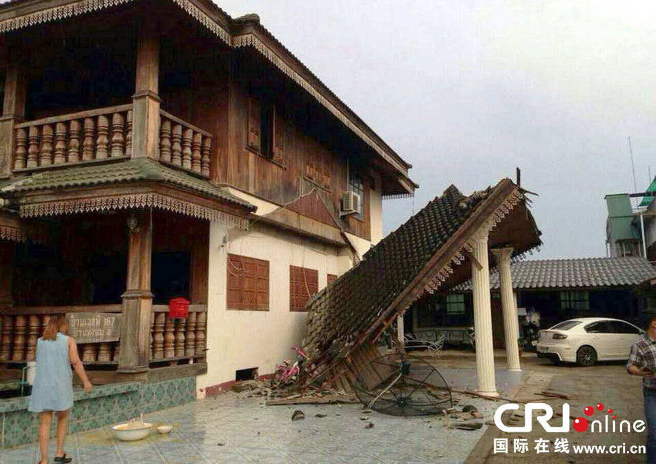 當(dāng)?shù)貢r間2014年5月5日，泰國清萊，一名婦女看著受損的房屋。 圖片來源：東方IC