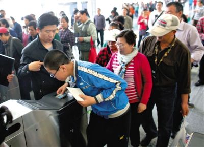 去年5月5日，14號(hào)線園博園站，乘客刷卡出地鐵。北京公交地鐵將實(shí)行計(jì)程票制，多乘坐多付費(fèi)。