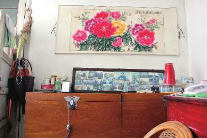 　陳會英將兒女的照片都裱起來，裝在一個大相框里，放在箱子上經(jīng)?？?，其中最多的就是劉金國的照片。