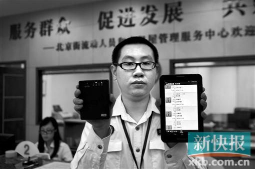 　越秀區(qū)北京街出租屋外來(lái)暫住人員管理服務(wù)中心的工作人員展示到出租屋登記來(lái)穗人員信息的儀器。