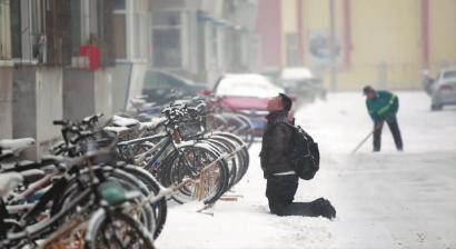 小伙子跪在樓前，一直抬頭看著樓上。 孫立國/攝