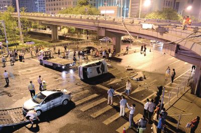路虎沖下國貿(mào)橋砸中一輛起亞轎車，橋上厚達幾十厘米的水泥護欄被撞斷，碎石四處散落，數(shù)十群眾在現(xiàn)場圍觀。