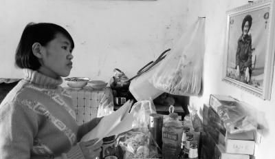 錢仁鳳站在母親遺像前。未能見母親最后一面是她的一大遺憾。