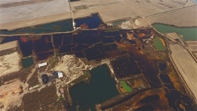 4月19日，廊坊市大城縣南趙扶鎮(zhèn)，津保路以北約八九百米處，一個巨大的污水坑中，水體呈現(xiàn)紅褐色。 新京報記者 尹亞飛 攝