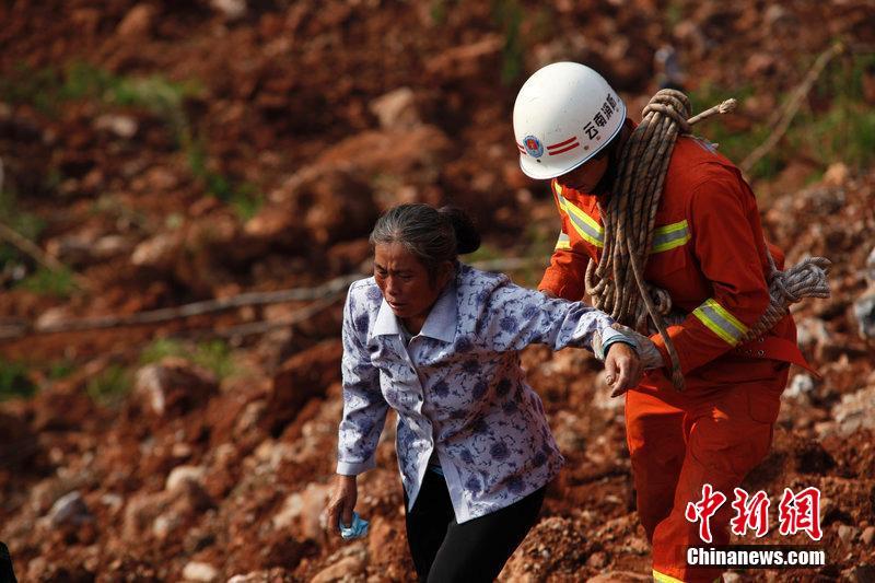 一位消防戰(zhàn)士將一位失去親人的老人扶離滑坡點(diǎn)。