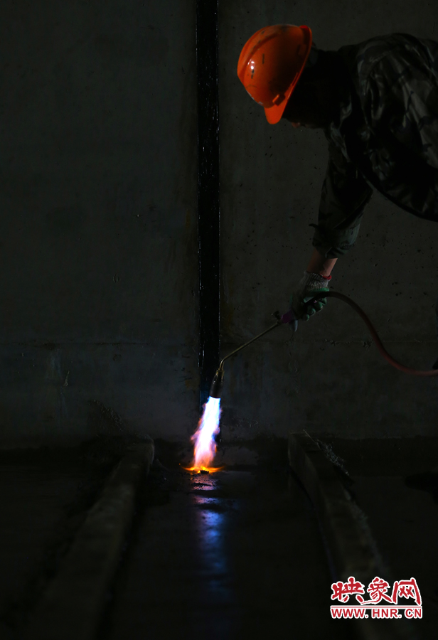 工人師傅用噴槍烘干地面，便于做防水處理