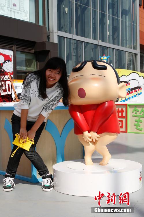 4月22日，游客與蠟筆小新合影?！跋灩P小新25周年紀(jì)念特展”日前在北京開展，吸引了不少市民游客。