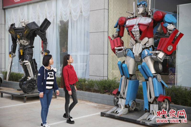 10月14日，市民在參觀河南省平頂山市寶豐縣一家企業(yè)門前的“變形金剛”。