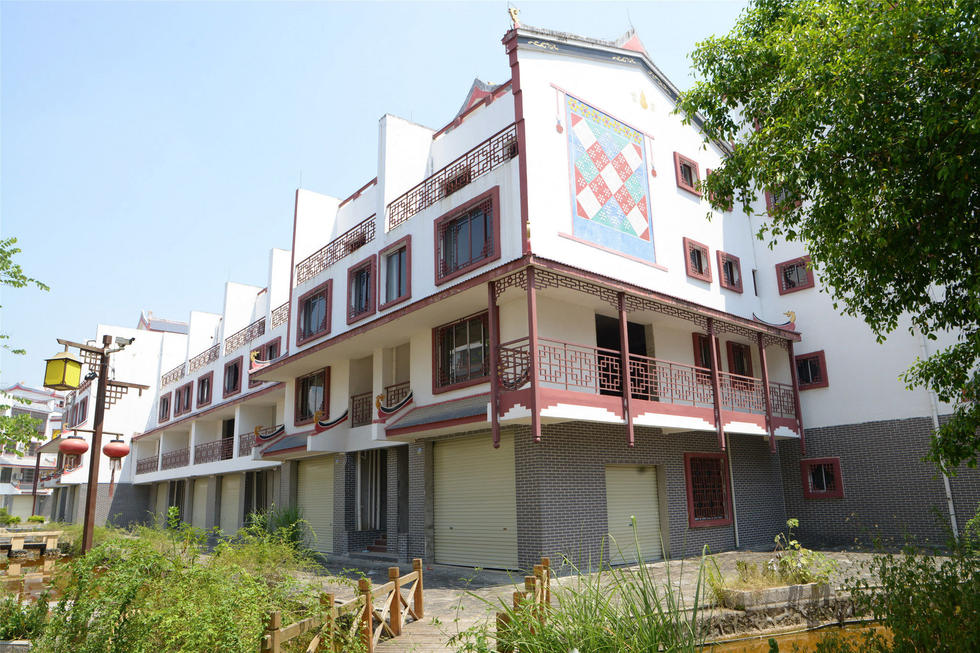 2016年7月26日，村民在廣西來賓市忻城縣隆達山水福城荒廢別墅間放牛。