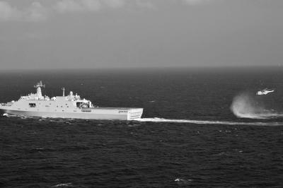 11日，抵達馬航飛機失聯(lián)海區(qū)的海軍井岡山艦與艦載直升機協(xié)同展開立體搜救行動。新華社發(fā)