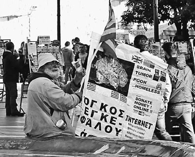 自債務危機爆發(fā)以來，希臘承諾實施以減薪、增稅、裁員和私有化為主要內容的緊縮和改革政策。一系列的緊縮措施使民眾生活受到嚴重影響，約1/4的家庭陷入貧困。圖為今年1月希臘大選期間，在雅典市中心國會大廈前廣場乞討的老人。