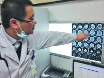 醫(yī)生在查看男孩的腦部CT片。薛馬義 攝