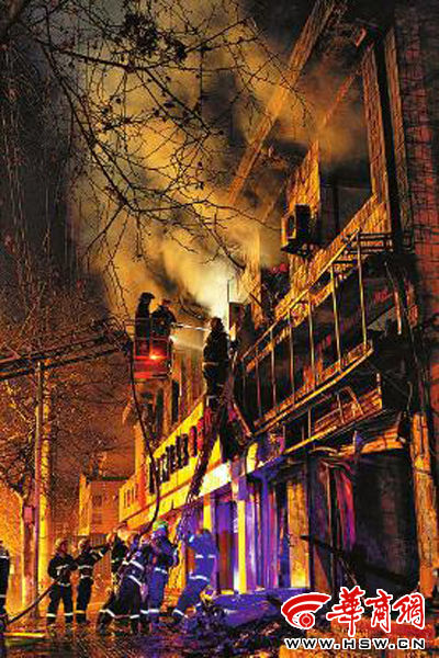 昨日22時10分，西安市豐慶路南小巷南口，消防官兵架梯子登上二樓施救 本組圖片由本報記者 閆文青 攝