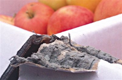 8月29日，新發(fā)地市場，一箱用“加重紙箱”包裝的蘋果正待售，紙箱夾層內(nèi)灰黑色的增重填充物清晰可見