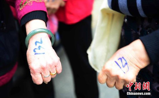 圖為10月28日，在江西九江市一家羊絨皮草服裝服飾博覽會現(xiàn)場，老人們正在頂著寒風(fēng)排隊等待領(lǐng)取10元代金劵。